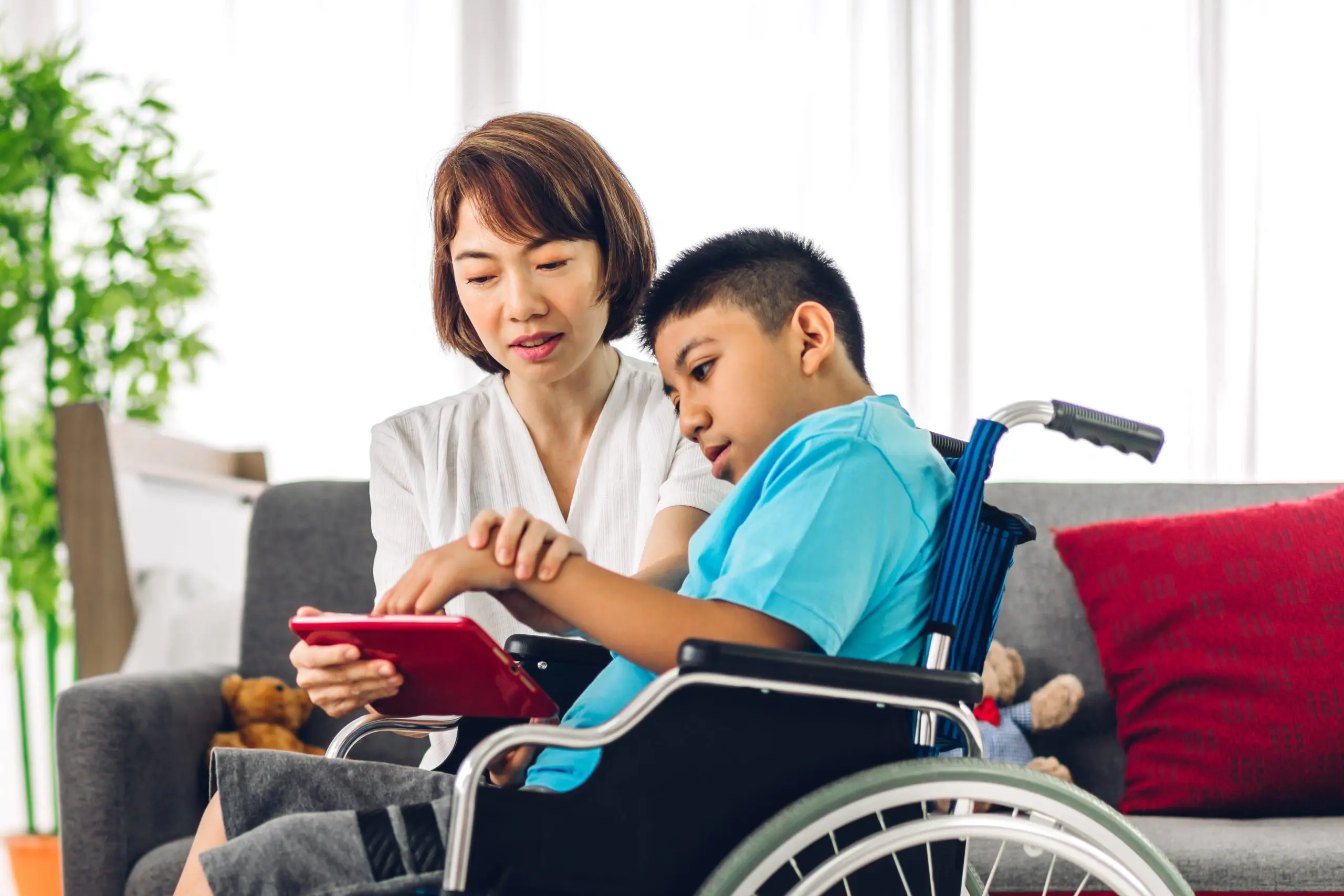 Parent using tablet device with child with SEND.