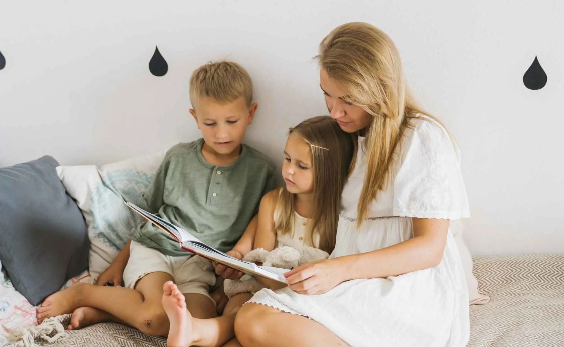 Mum sat reading a book with two children