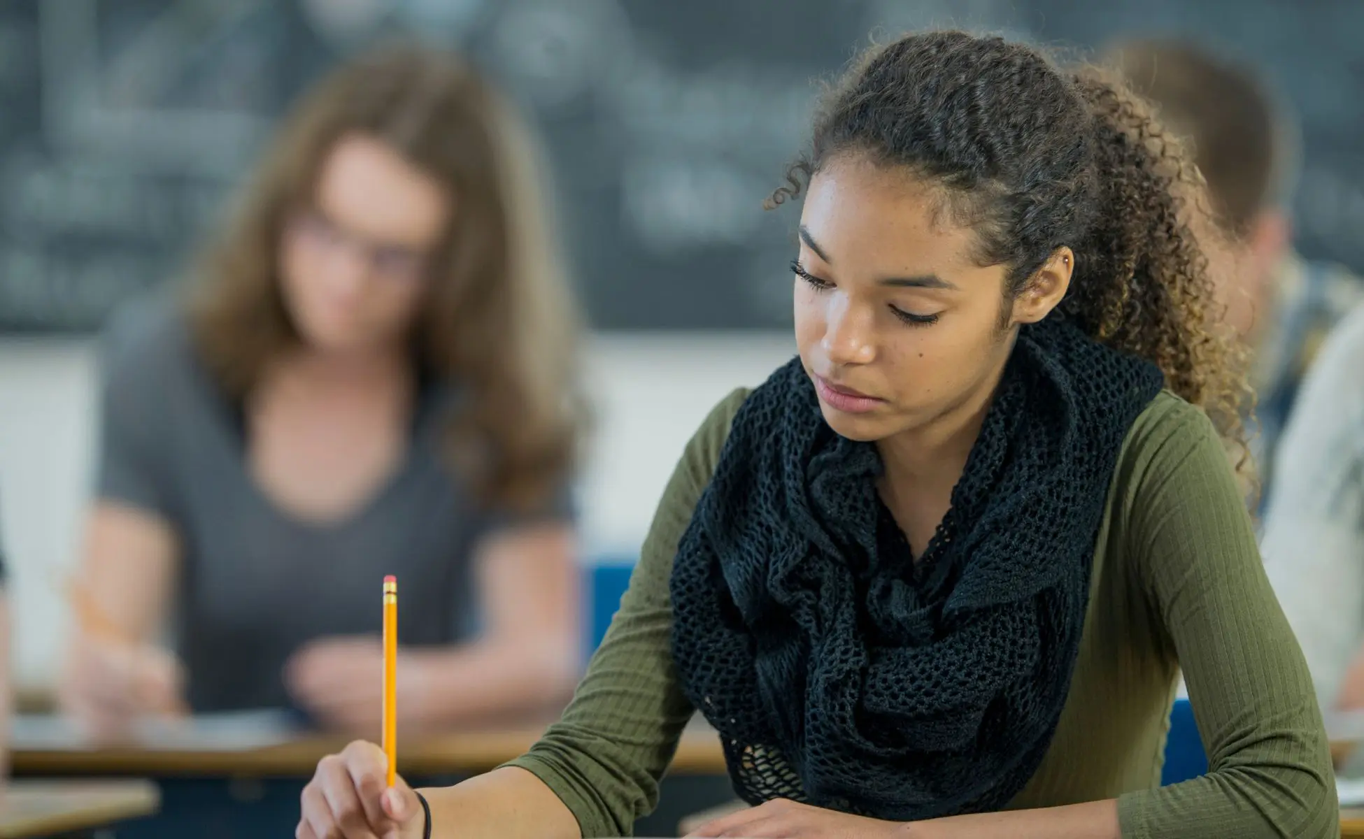 how can exam season impact a grieving young person. Image featuring a young girl sitting an exam