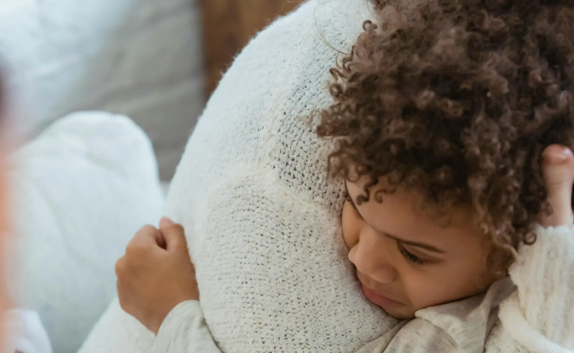 Close up of young mixed race child hugging adult