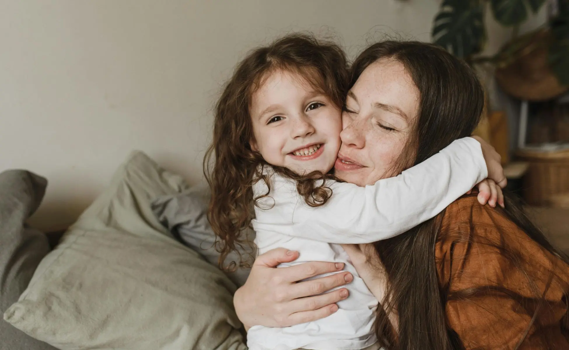 Woman hugging small child on the sofa