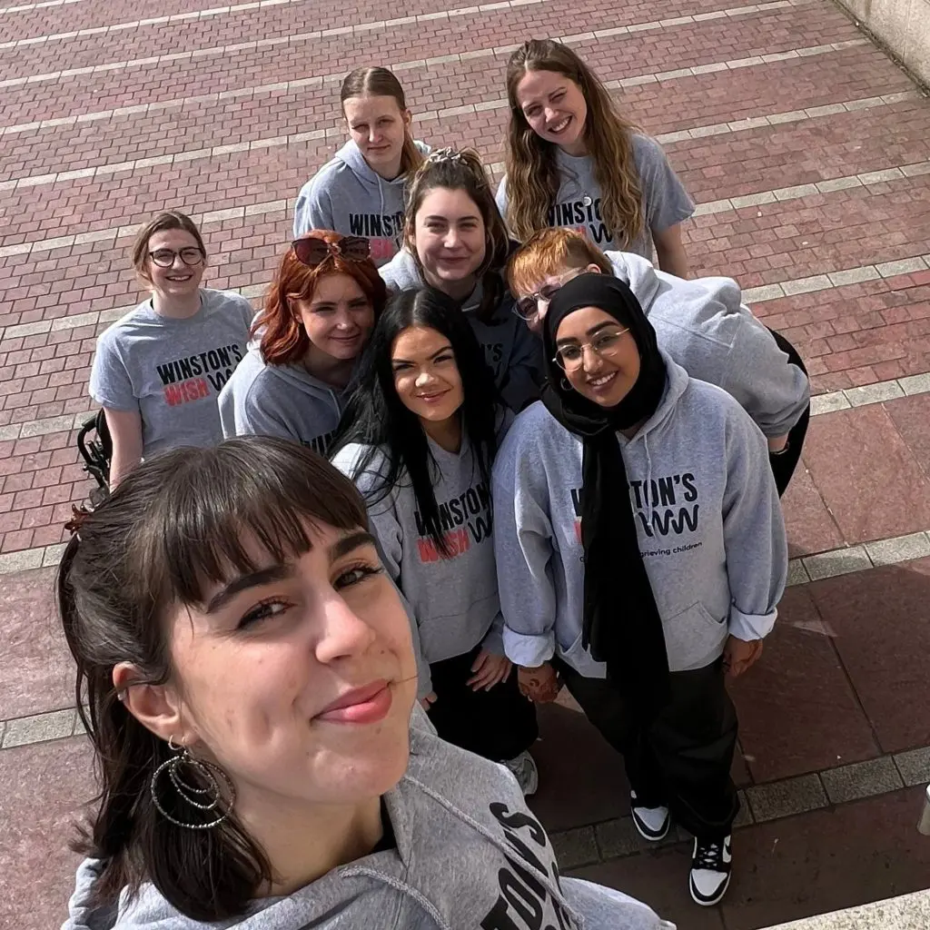 Youth Team members gathered together taking a selfie in their Winston's Wish hoodies