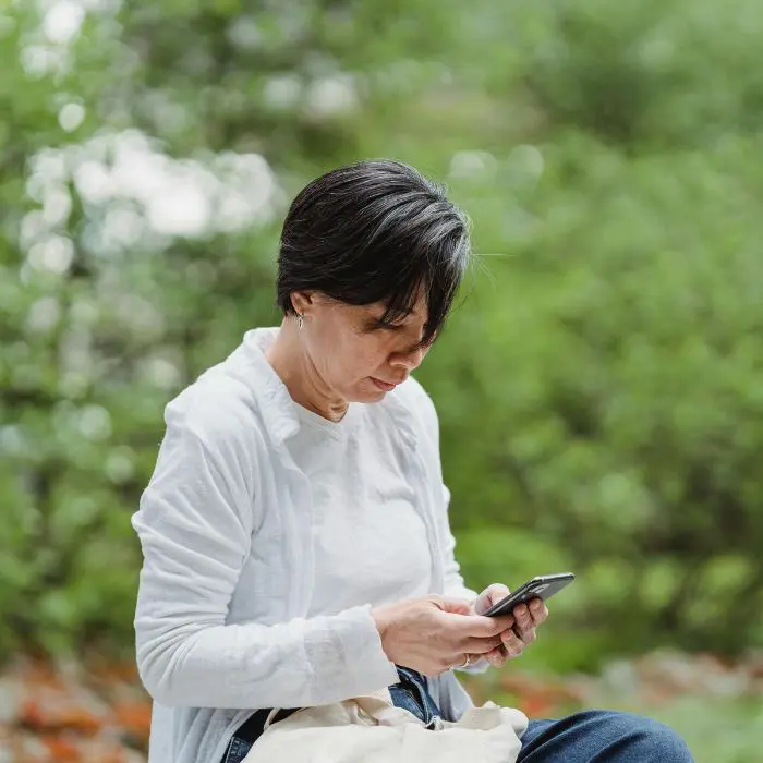 ABC page Adults with unresolved grief Female sat outside on her phone