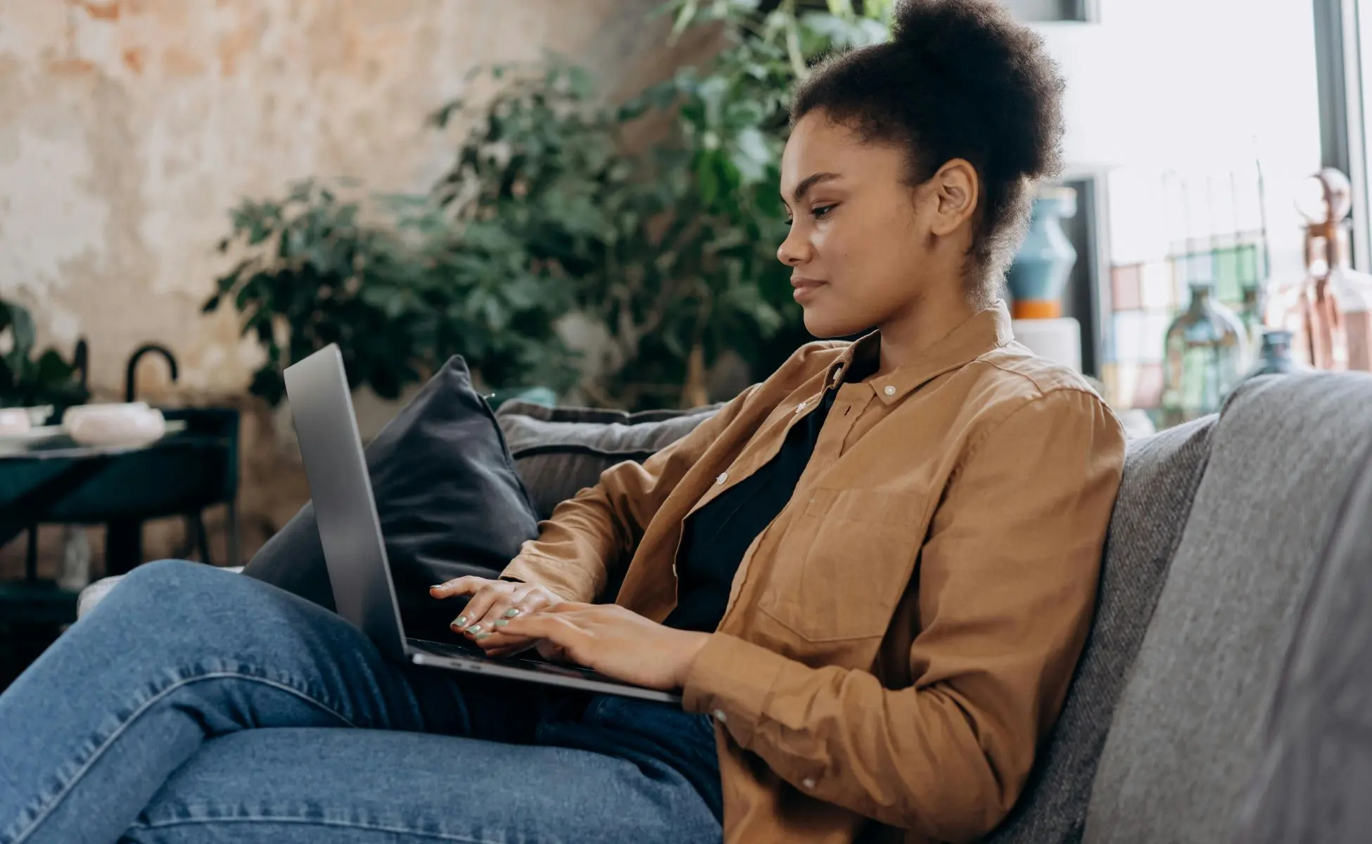 Woman sat on couch using a laptop - Adults Bereaved as Children