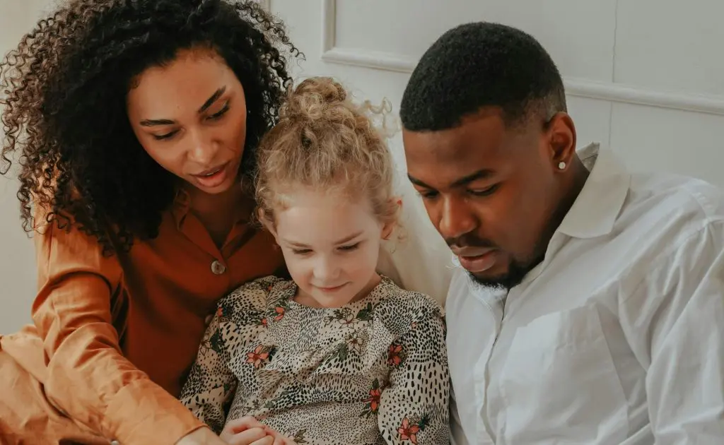 Man and Woman reading a book to a foster child