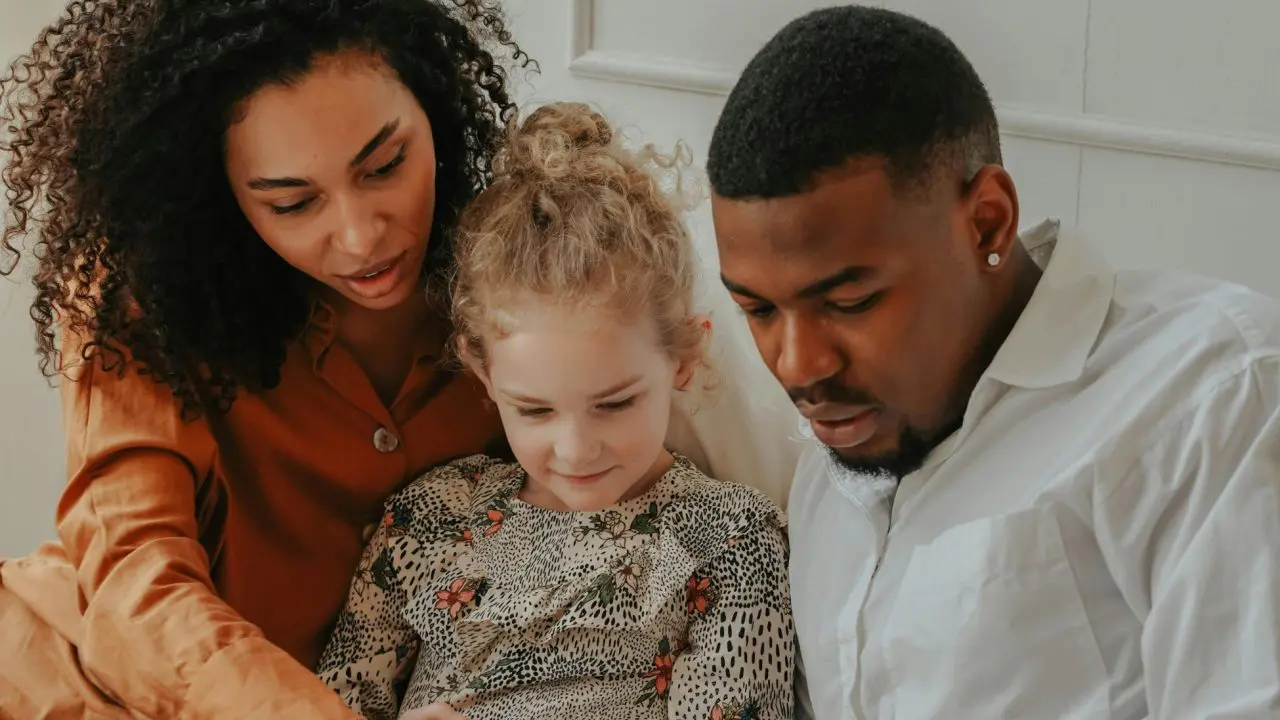 Man and Woman reading a book to a foster child