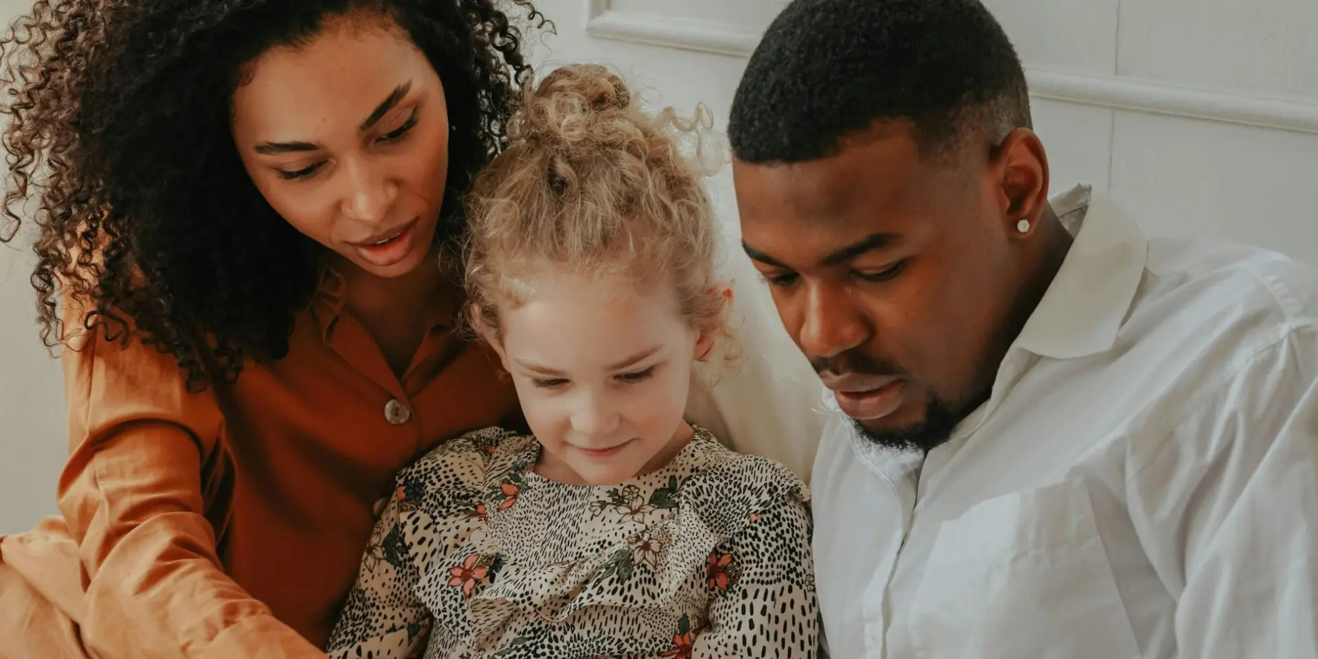 Man and Woman reading a book to a foster child