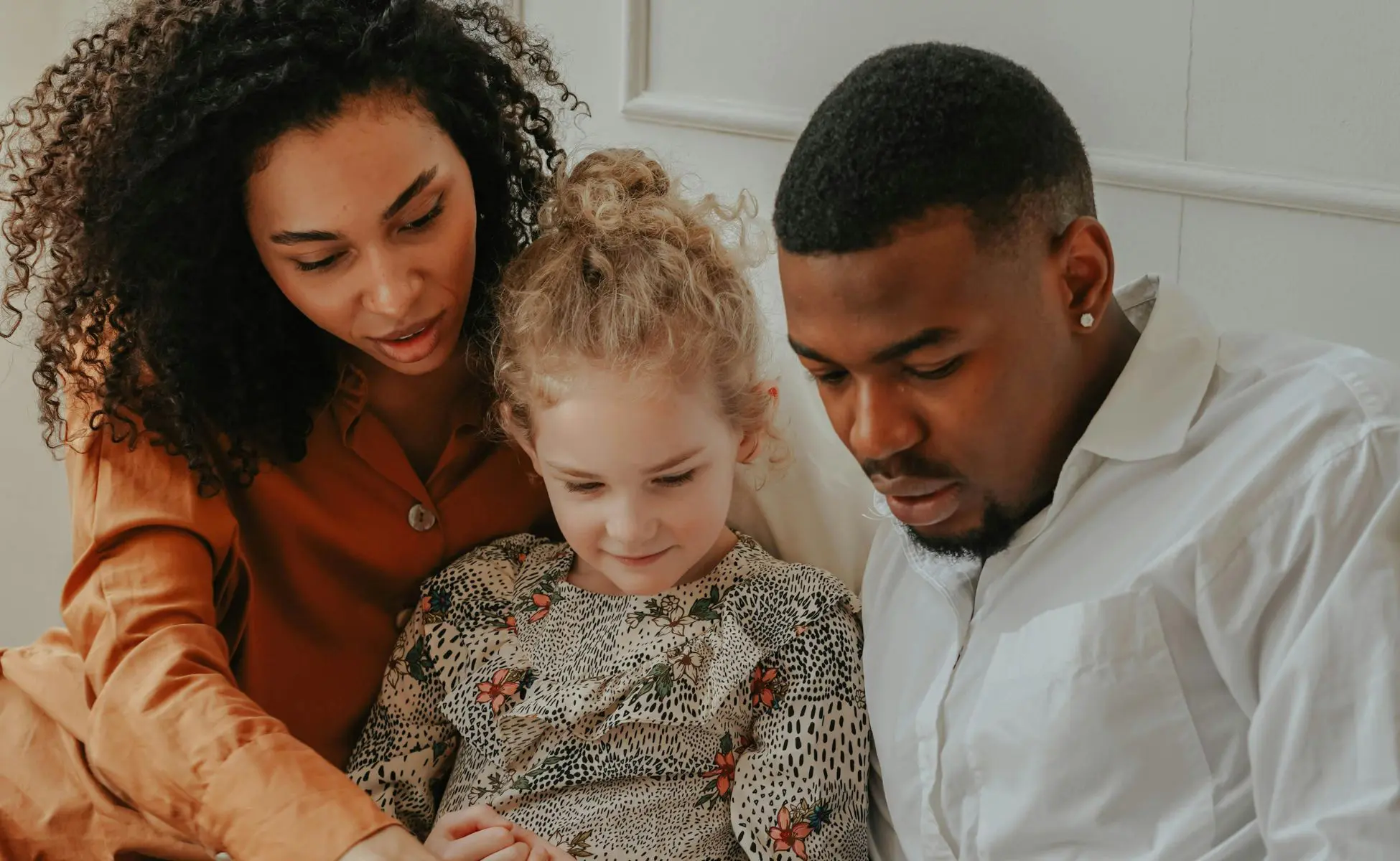 Man and Woman reading a book to a foster child