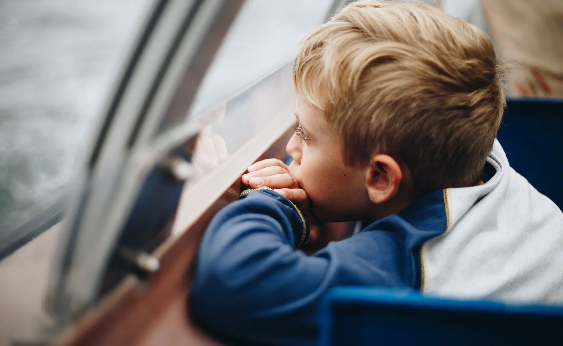 Are my children too young to know how their parent or sibling died: small boy with blonde hair looking out of the window
