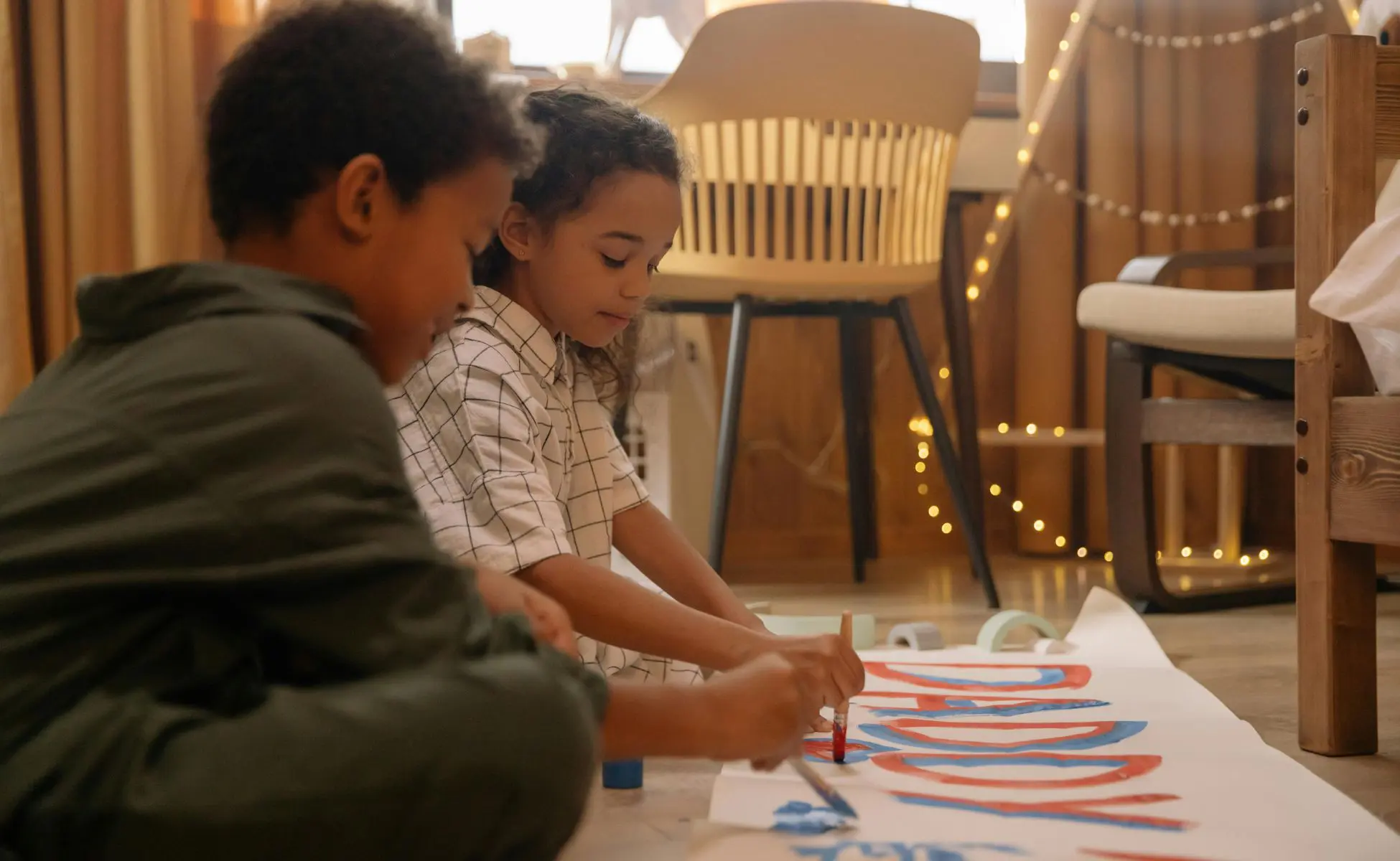 Helping a child remember someone who has died: two children painting a banner that reads 'Daddy'