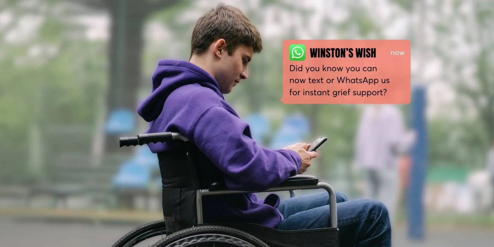 Teenage boy in a wheelchair using a phone.