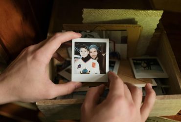 Memory-box Hands holding a polaroid photo of a child with their dad