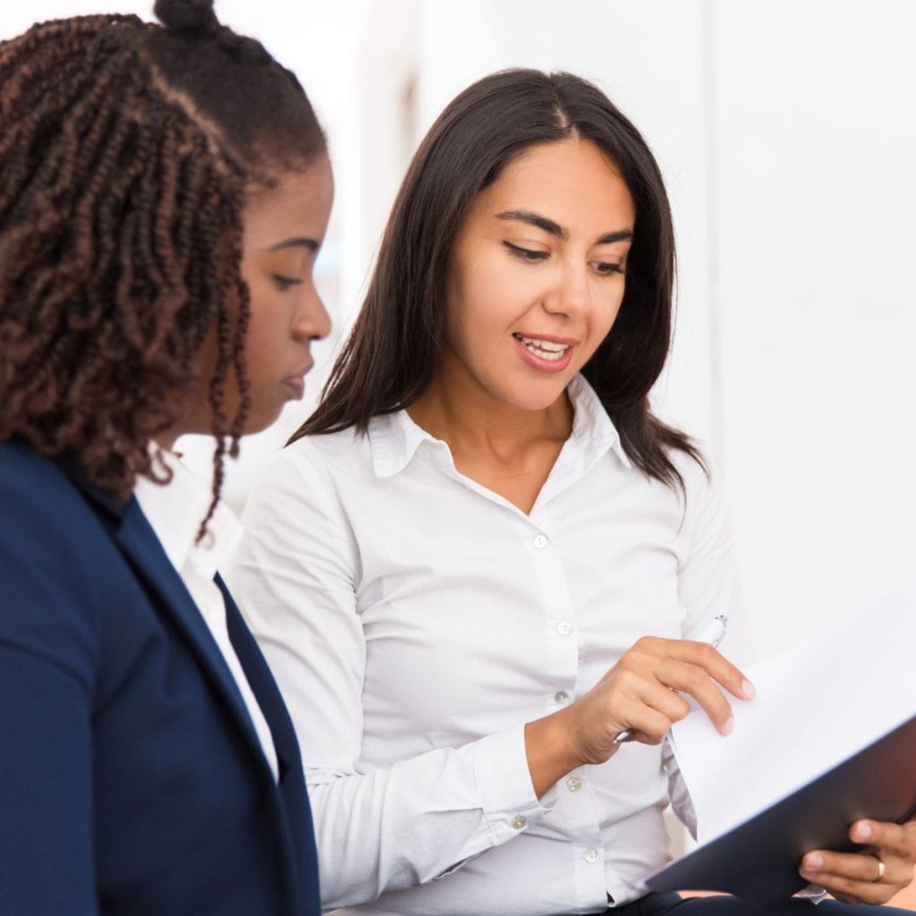 Free Will's Month Two women sat side by side reviewing legal documents