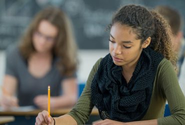 how can exam season impact a grieving young person. Image featuring a young girl sitting an exam