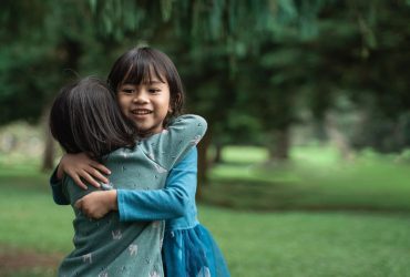 Two children hugging in the park
