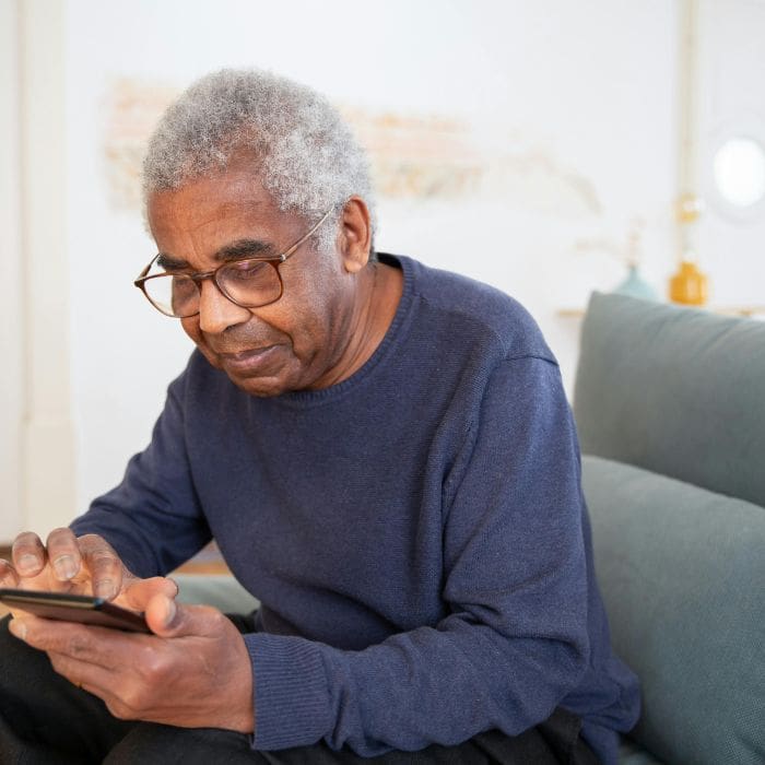 Older black man searching on his phone