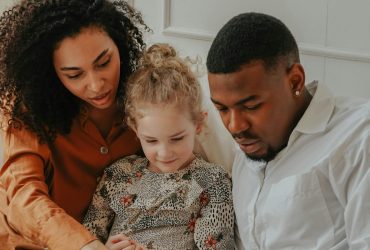 Man and Woman reading a book to a foster child