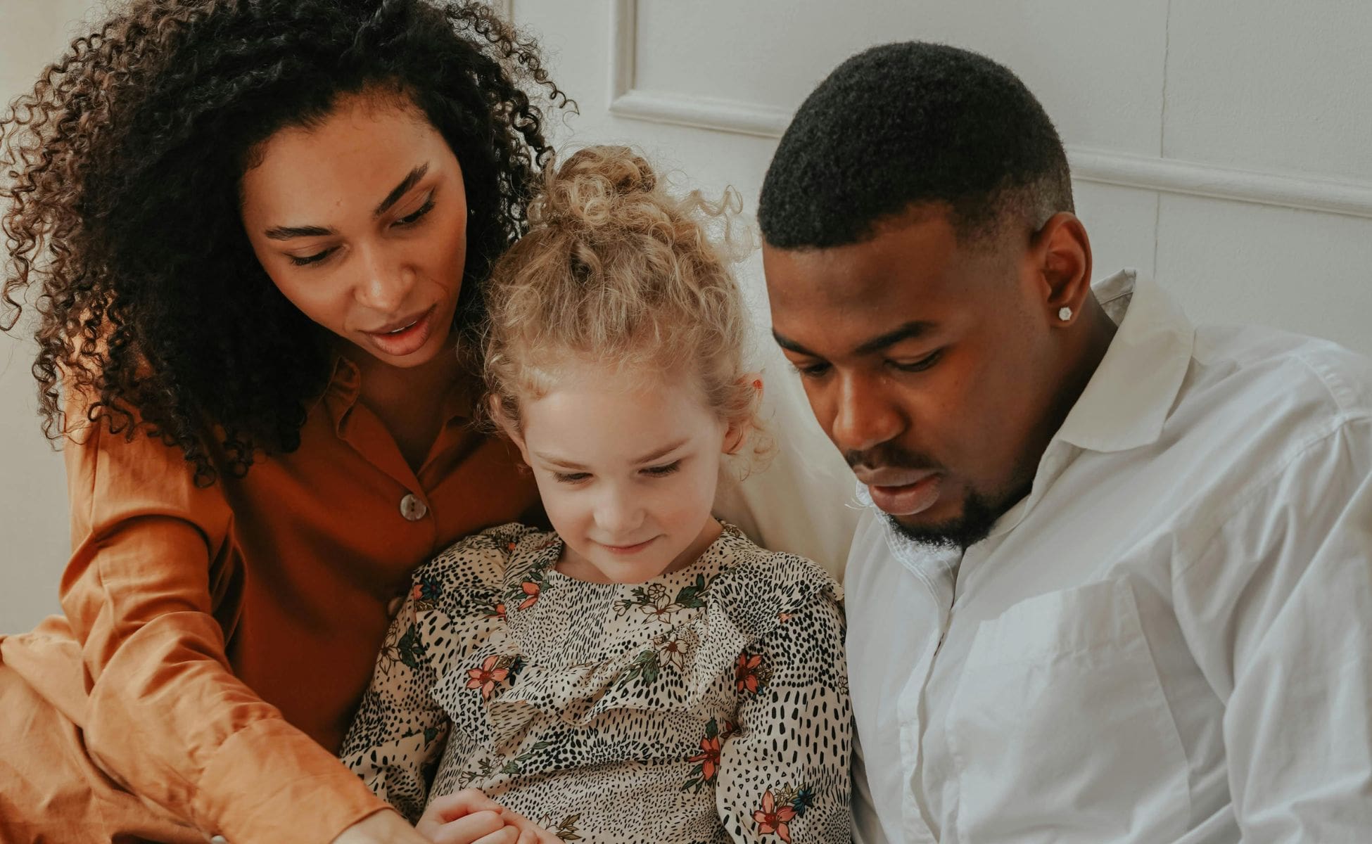 Man and Woman reading a book to a foster child