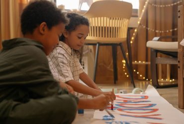 Helping a child remember someone who has died: two children painting a banner that reads 'Daddy'